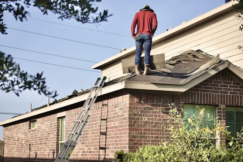 Professional roofer working on a residential roof in Manistee